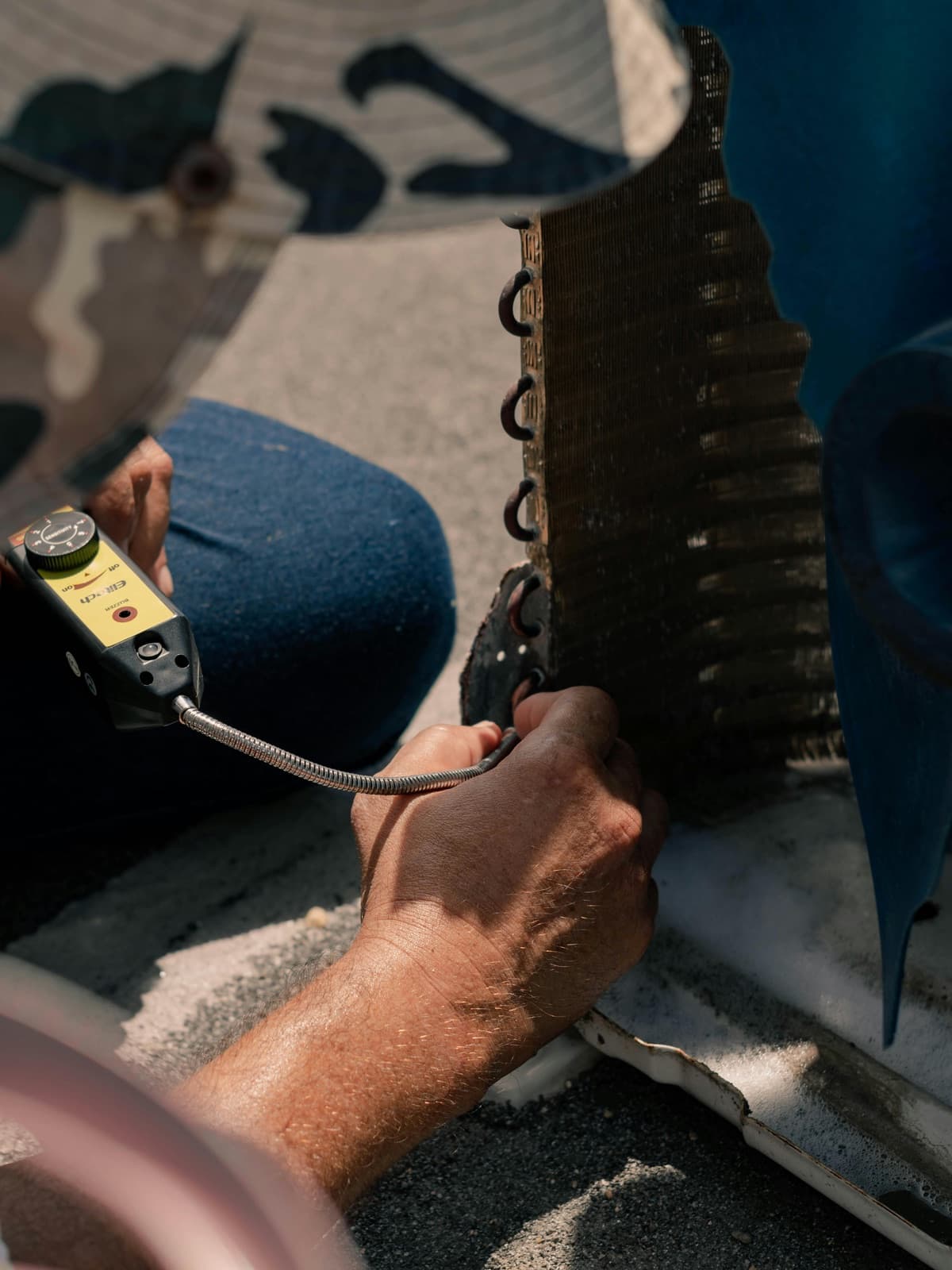 Close-up of an outdoor air conditioner coil being serviced.